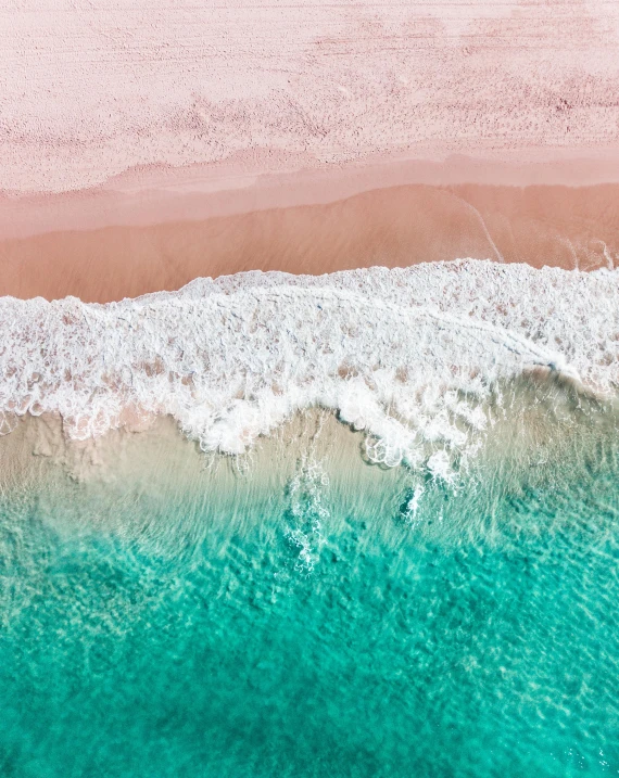 a large body of water next to a sandy beach, pexels contest winner, pink white turquoise, taking from above, ocean spray, well edited