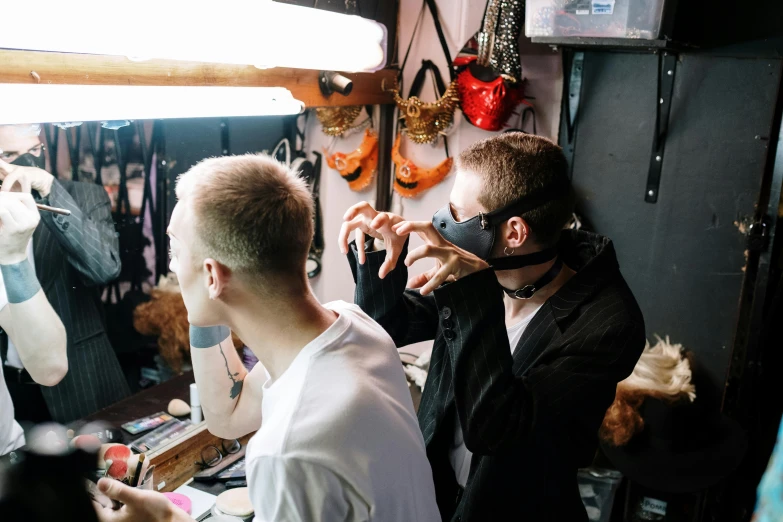 a couple of men standing in front of a mirror, pexels contest winner, body modification, wearing a mask, behind the scenes, wolfy nail