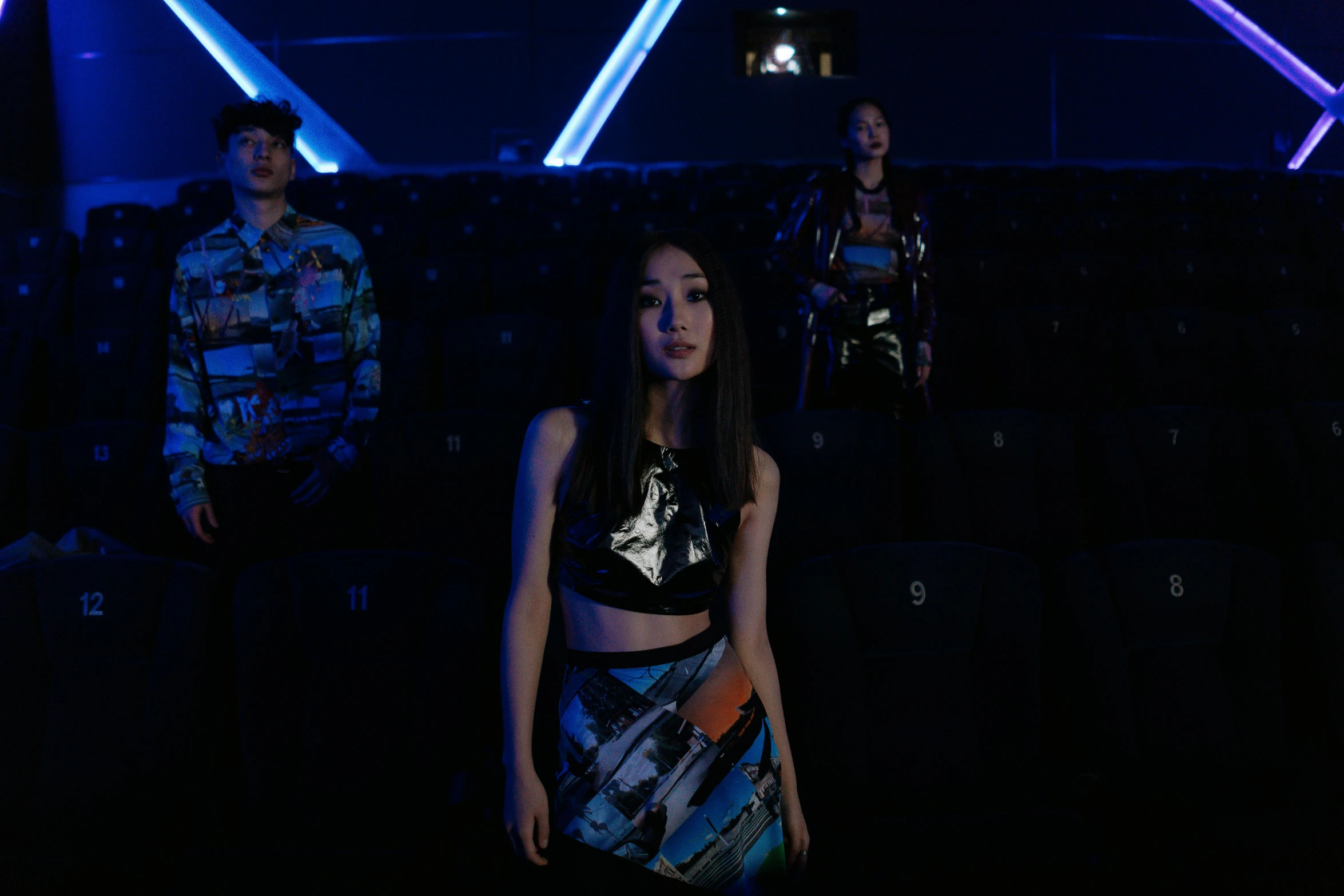 a group of people standing next to each other in a dark room, an album cover, by Julia Pishtar, unsplash, holography, dilraba dilmurat, wearing a crop top, on a spaceship, wenjun lin