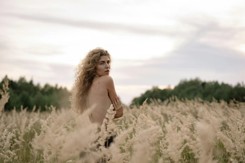 a naked woman standing in a field of tall grass, by Emma Andijewska, pexels contest winner, naturalism, pale skin curly blond hair, early evening, angelina stroganova, biophilia