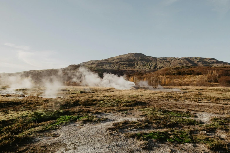 a field that has some steam coming out of it, by Hallsteinn Sigurðsson, trending on unsplash, standing on rocky ground, on a sunny day, high quality product image”