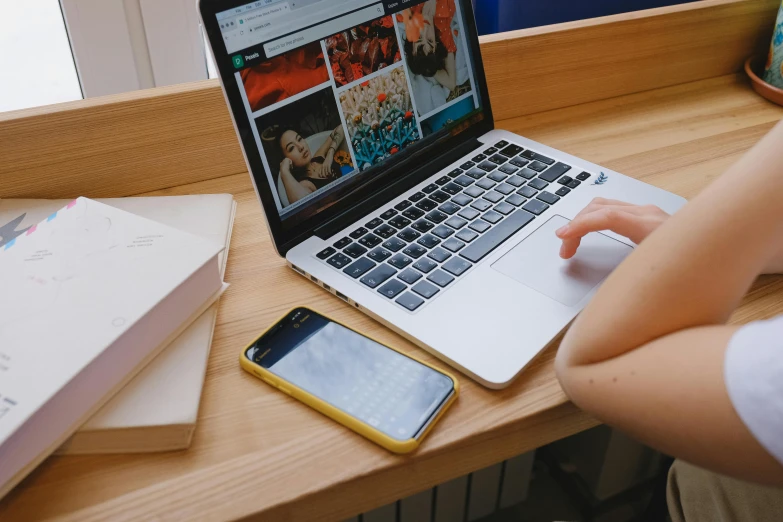 a person sitting at a desk with a laptop and cell phone, a picture, by Julia Pishtar, trending on pexels, bottom angle, student, multiple stories, item