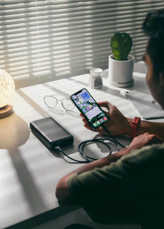 a person sitting at a table with a cell phone, a picture, satisfying cable management, qled, all black matte product, album