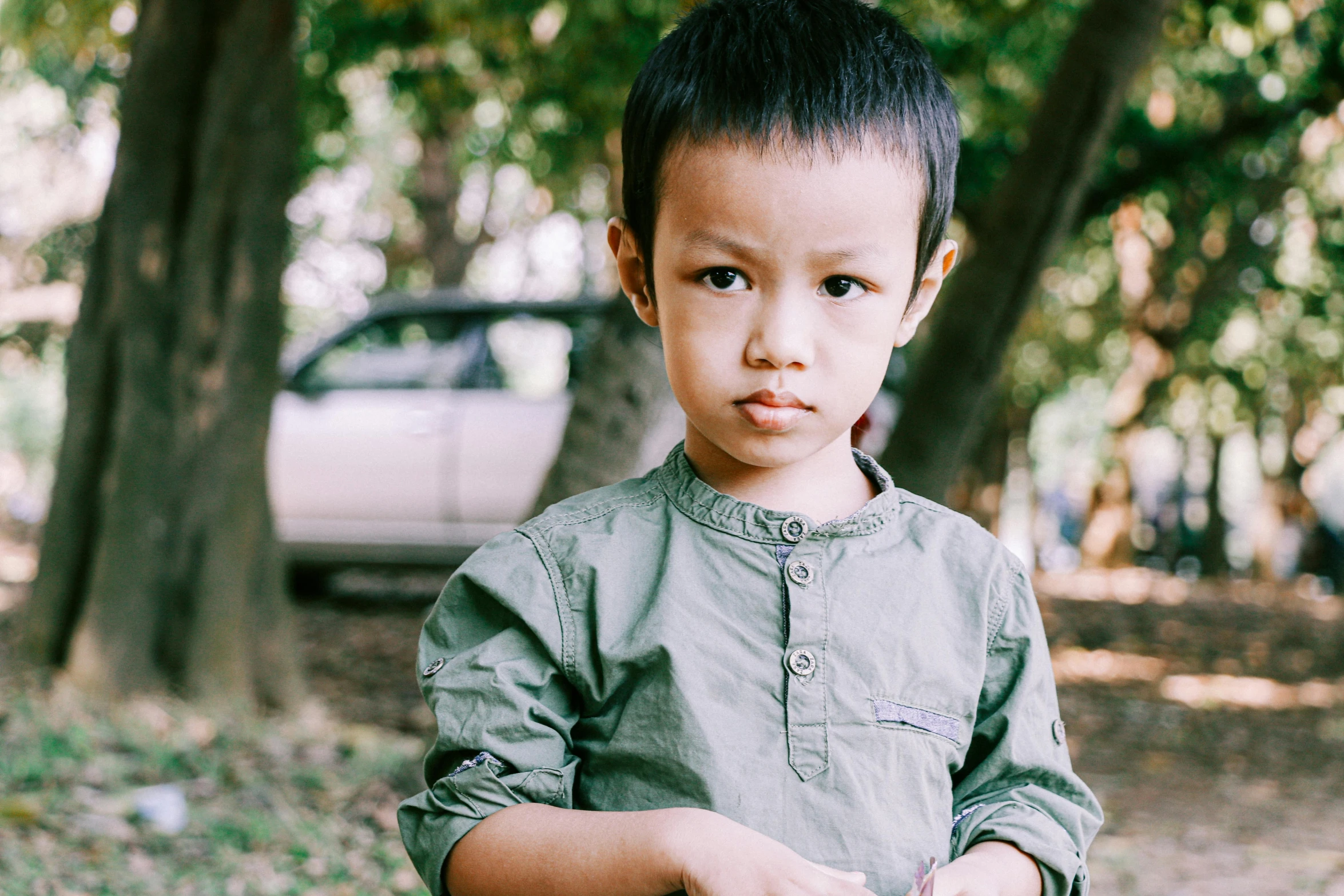 a young boy standing next to a fire hydrant, pexels contest winner, south east asian with round face, at a park, phong shaded, serious and stern expression