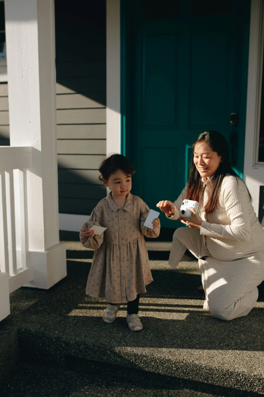 a woman and a child on the steps of a house, pexels contest winner, holding a boba milky oolong tea, inspect in inventory image, seattle, award-winning render