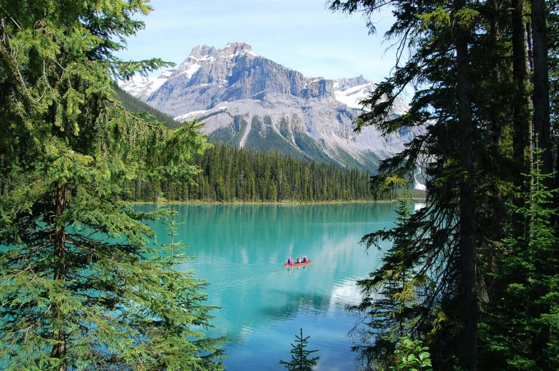 a couple of people in a boat on a lake, by Brigette Barrager, pexels contest winner, turquoise water, spruce trees, brilliant peaks, 2 0 2 2 photo