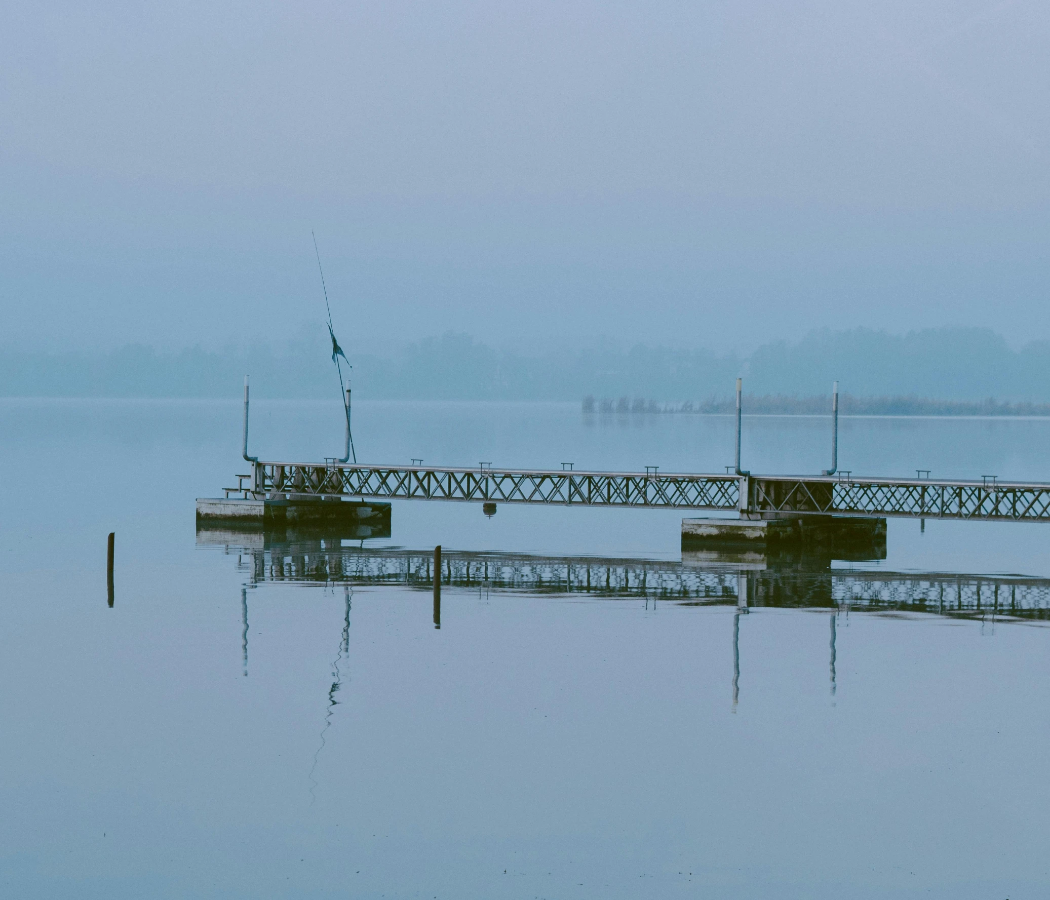 a dock in the middle of a body of water, an album cover, inspired by Pierre Pellegrini, pexels contest winner, tonalism, blue mist, fishing, uncropped, 2022 photograph