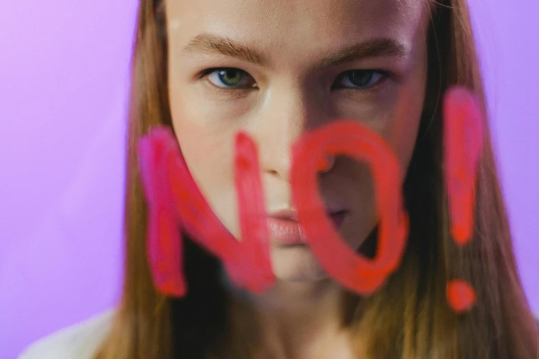 a close up of a person with long hair, a picture, by Emma Andijewska, trending on pexels, neo-expressionism, woman holding sign, with fluo colored details, sydney sweeney, annoyed expression