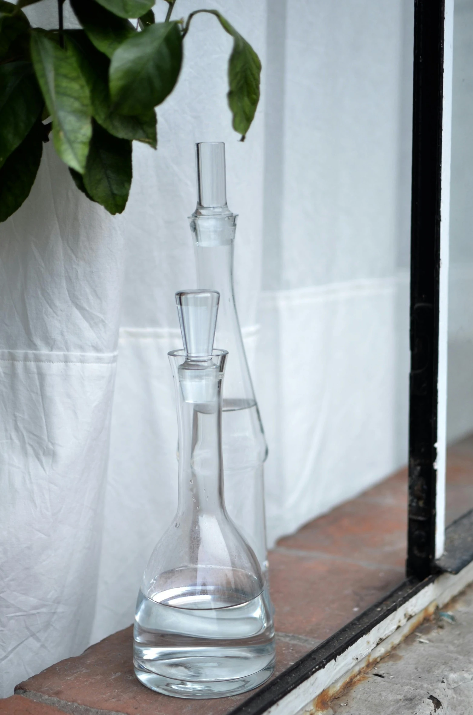 a couple of glass vases sitting on top of a window sill, an album cover, inspired by Diego Giacometti, unsplash, water pipe, clear detailed view, scientific glassware, full body close-up shot