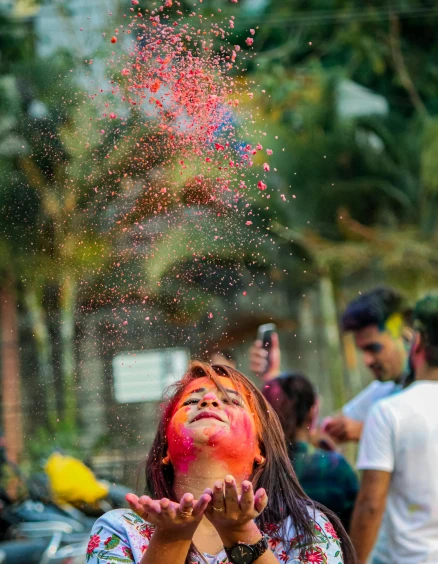 a woman throwing colored powder on her face, pexels contest winner, bengal school of art, instagram story, center of picture, holiday season, candid photography