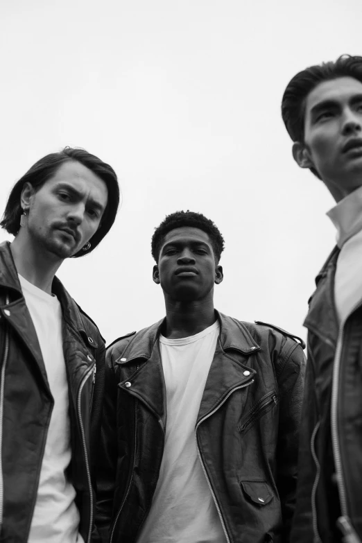 a group of men standing next to each other, a black and white photo, unsplash, wearing a leather jacket, an all white human, cheekbones, gradient