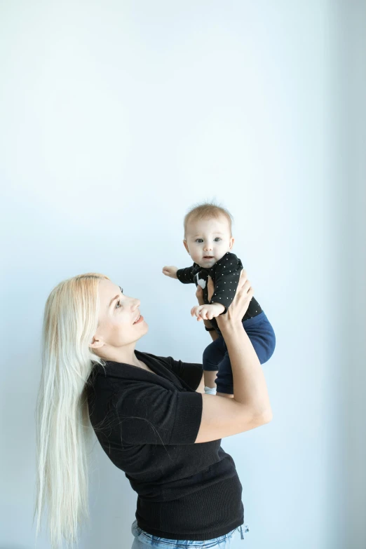 a woman holding a baby in her arms, unsplash, full body full height, a blond, professional photo-n 3, wētā fx