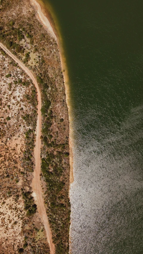 an aerial view of a large body of water, an album cover, by Lee Loughridge, trending on unsplash, land art, australian outback, loosely cropped, dirt road background, thumbnail