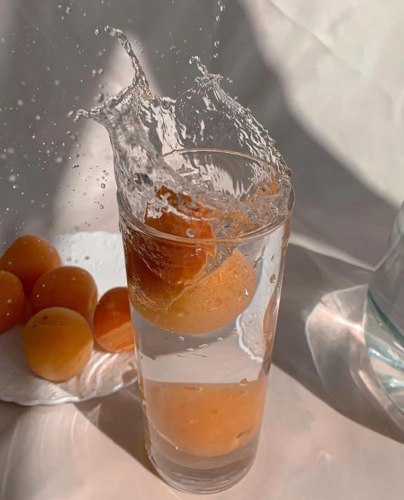 an orange being dropped into a glass of water, by Emma Andijewska, unsplash contest winner, photorealism, shot on iphone 1 3 pro, bubbly scenery, uwu hi-fructose, anime shot