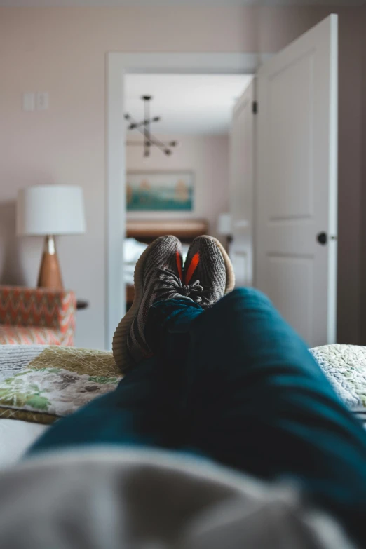 a person laying on a bed with their feet up, by Carey Morris, pexels contest winner, (heart), home setting, immaculately detailed, gif