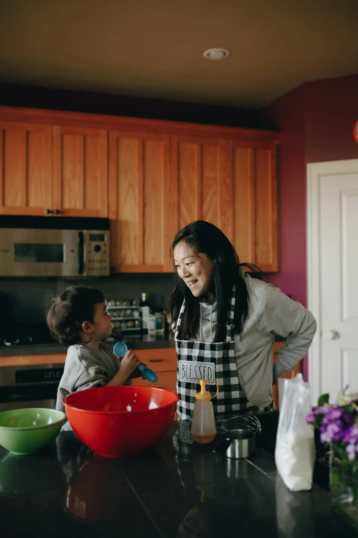 a woman standing next to a child in a kitchen, by Winona Nelson, pexels contest winner, jackie tsai style, on kitchen table, recipe, dwell