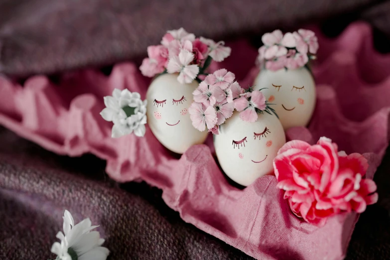 three decorated eggs sitting on top of a pink cloth, trending on pinterest, flowers covering eyes, close-up photo, alternate angle, serene smile