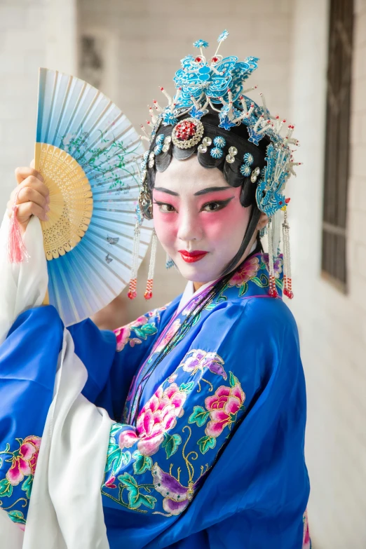 a woman in a blue kimono holding a fan, a portrait, inspired by Lan Ying, trending on unsplash, square, peking opera, in costume, slide show