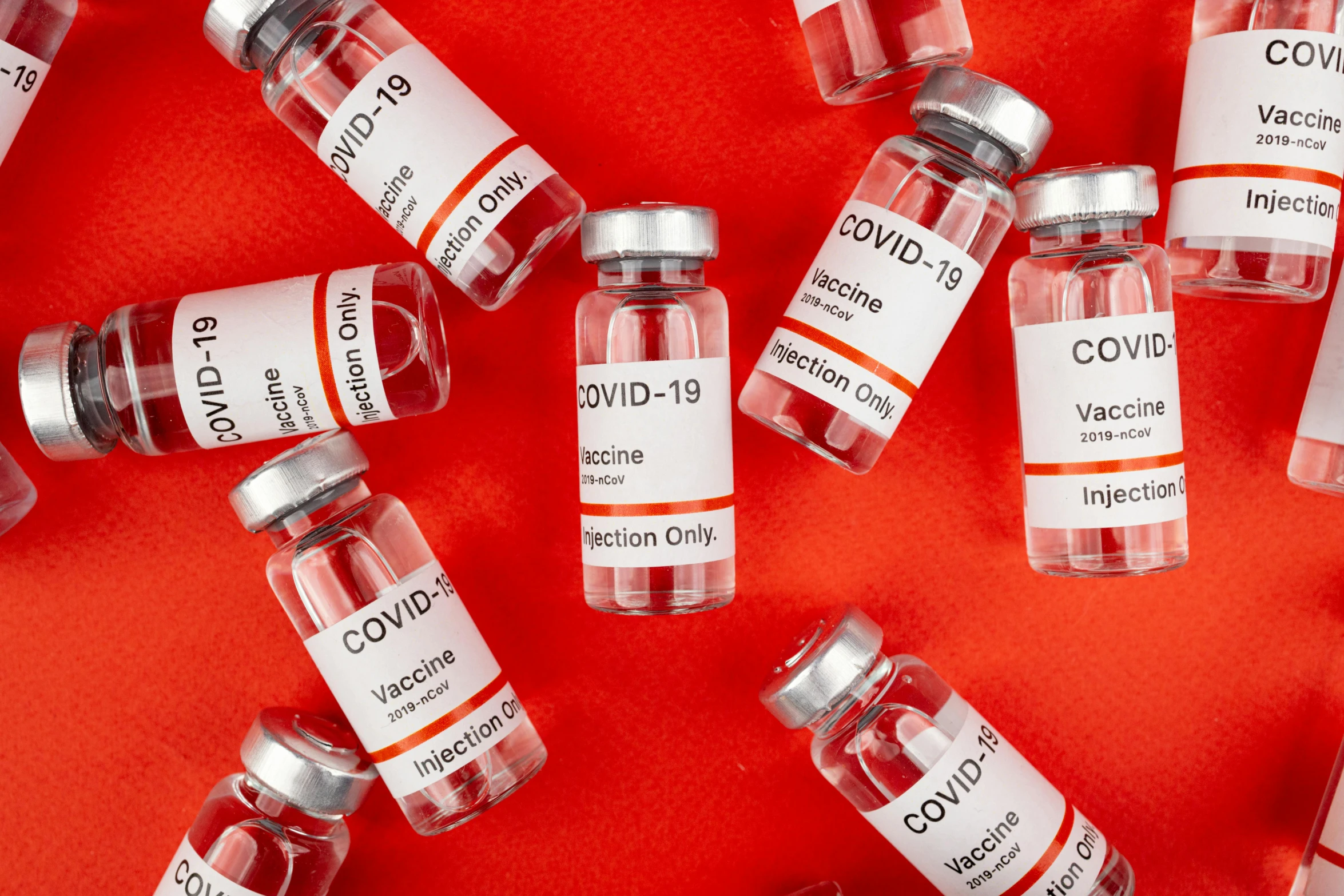 a bunch of vials sitting on top of a red surface, medical labels, ƒ / 3. 5, covid, white buildings with red roofs