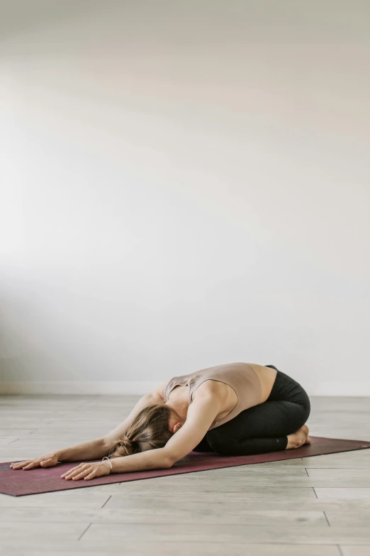 a woman in a yoga pose on a yoga mat, by Jessie Algie, unsplash, figuration libre, studio shot, low quality photo, relaxed posture, exhausted
