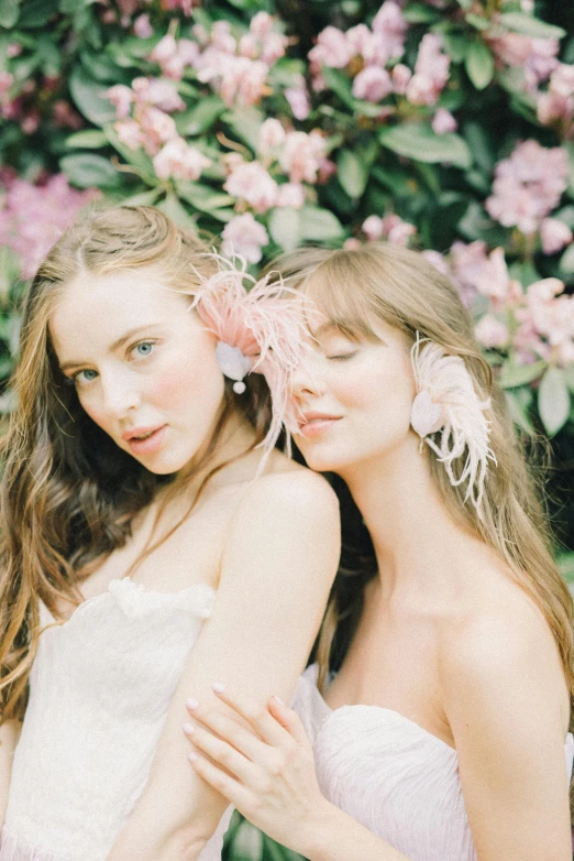 two women standing next to each other with flowers in their hair, trending on pexels, rococo, soft blush, feathered, julia sarda, editorial footage