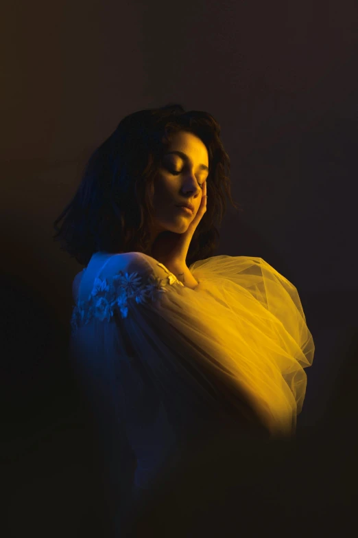 a woman in a white dress standing in a dark room, an album cover, inspired by Elsa Bleda, pexels contest winner, with yellow cloths, charli xcx, portrait soft light, dolman