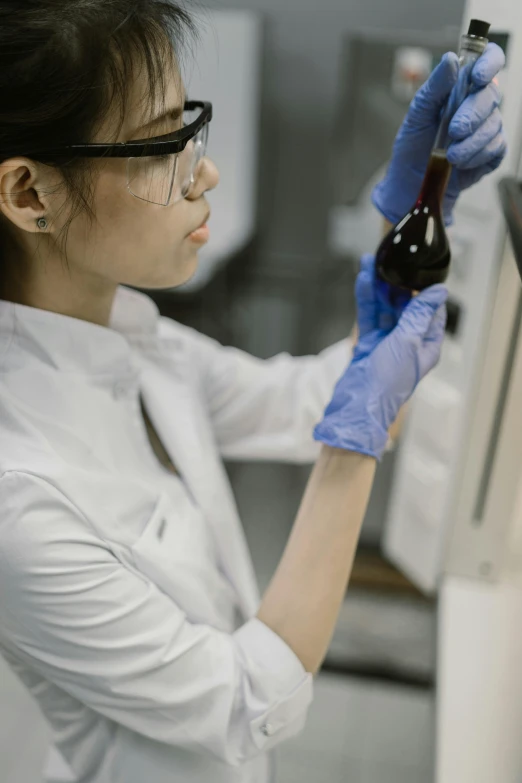 a woman in a lab coat holding a bottle, process art, maroon, modular graphene, wearing an academic gown, black