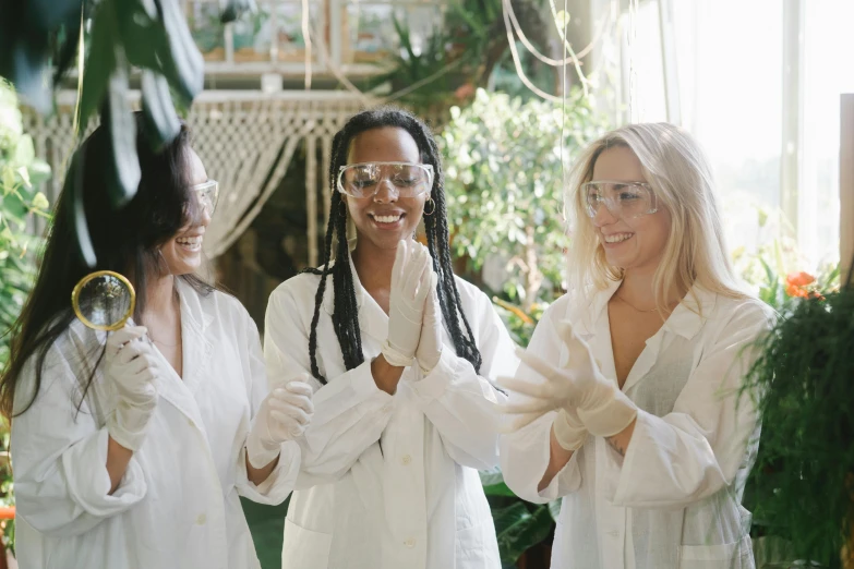 a group of women standing next to each other, by Emma Andijewska, pexels contest winner, experimenting in her science lab, botanical garden, white glasses, flirting