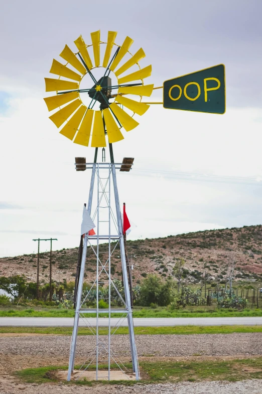 a yellow and green windmill sitting on the side of a road, inspired by Dorothea Lange, square, julian ope, sign, oops