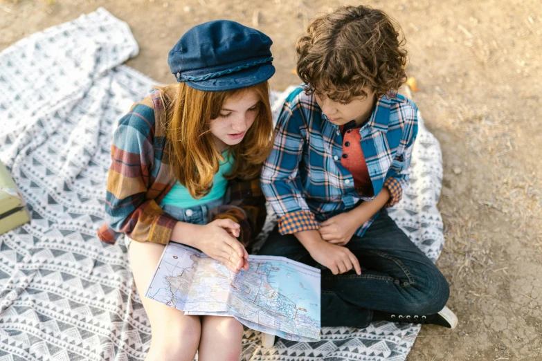 two children sitting on a blanket looking at a map, a portrait, by Alice Mason, pexels, brunette boy and redhead boy, blue print, female explorer mini cute girl, thumbnail