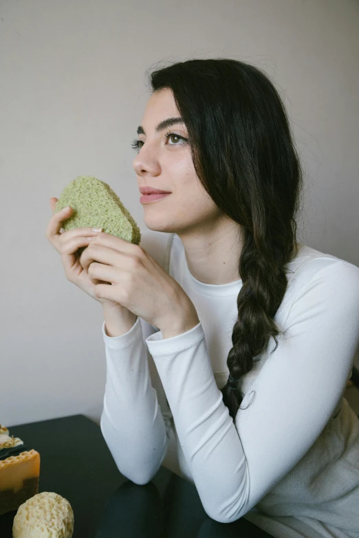 a woman sitting at a table eating a sandwich, inspired by Elsa Bleda, trending on pexels, renaissance, face profile, sage green, made of food, sponge