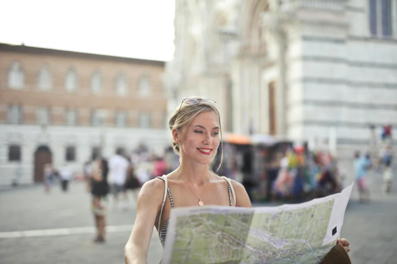 a woman is holding a map and smiling, by Giuseppe Avanzi, pexels contest winner, square, sienna, white, travel ad