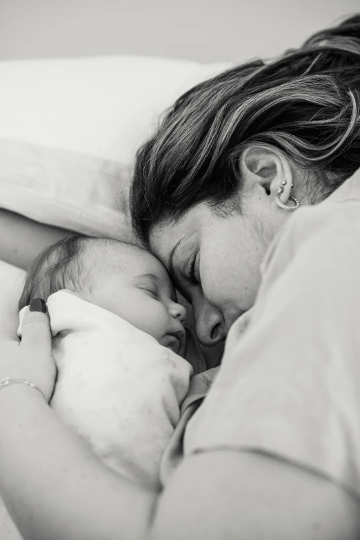 a black and white photo of a woman holding a baby, a black and white photo, by Lee Loughridge, pexels, sleeping, manuka, instagram photo, 6 : 3 0 am