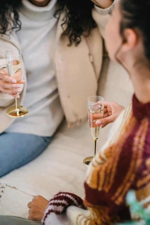 two women sitting on a couch holding wine glasses, pexels contest winner, romanticism, subtle gold accents, drinking champagne, slightly minimal, zoomed in