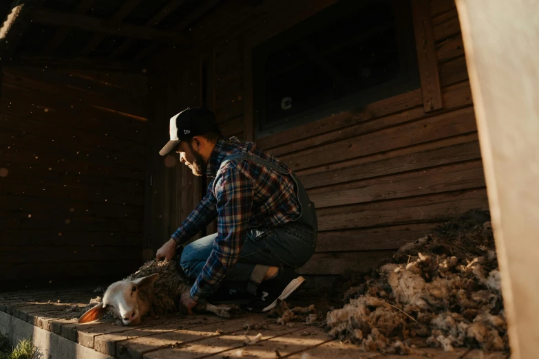 a man kneeling down next to a pile of wood, pexels contest winner, sheep wool, inside of a cabin, profile image, thumbnail