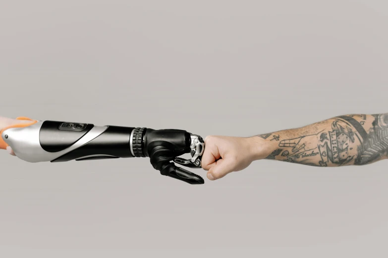 a close up of a person holding an object in their hand, a tattoo, trending on pexels, futurism, robotic prosthetic arm, on a gray background, reaching out to each other, portrait of an ai