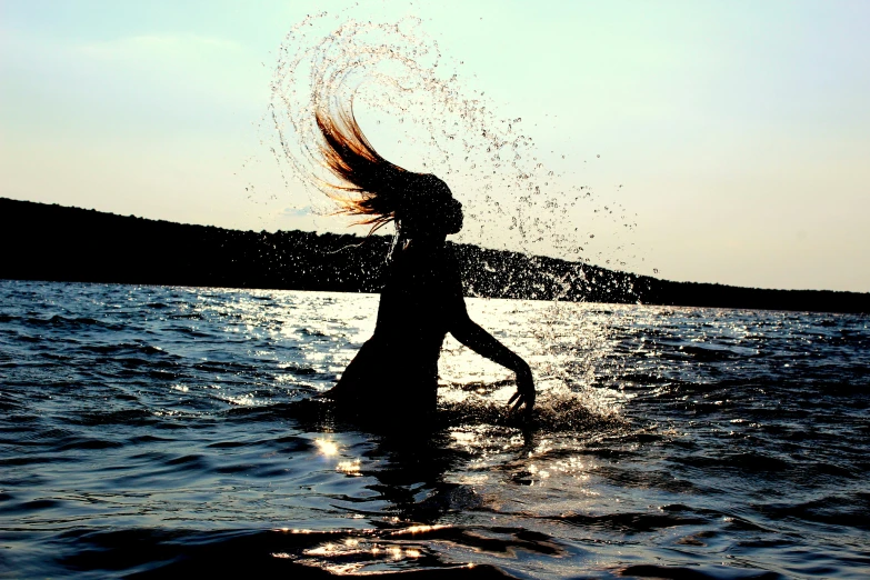 a woman splashes her hair in the water, by Caroline Mytinger, pexels contest winner, silhuette, slide show, splash image
