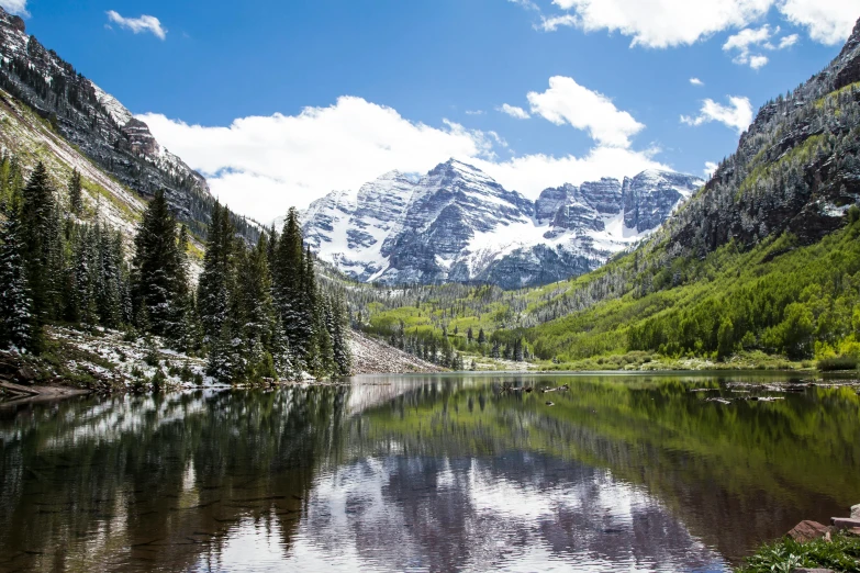 a body of water surrounded by trees and mountains, a photo, colorado mountains, avatar image