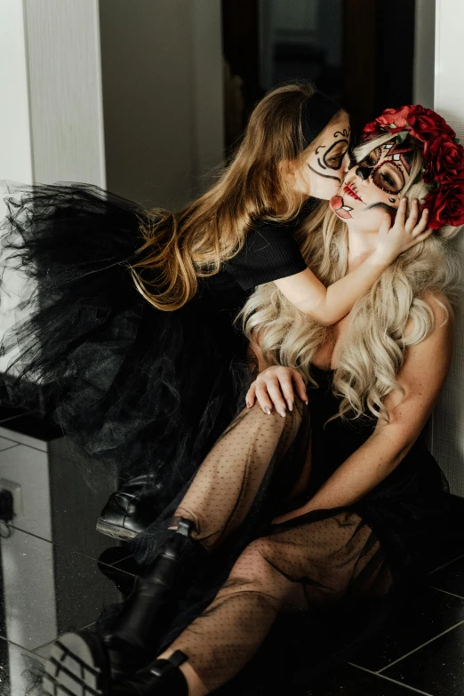 a couple of women sitting next to each other, inspired by Hedi Xandt, trending on pexels, gothic art, kissing together cutely, halloween celebration, black mask, a blond