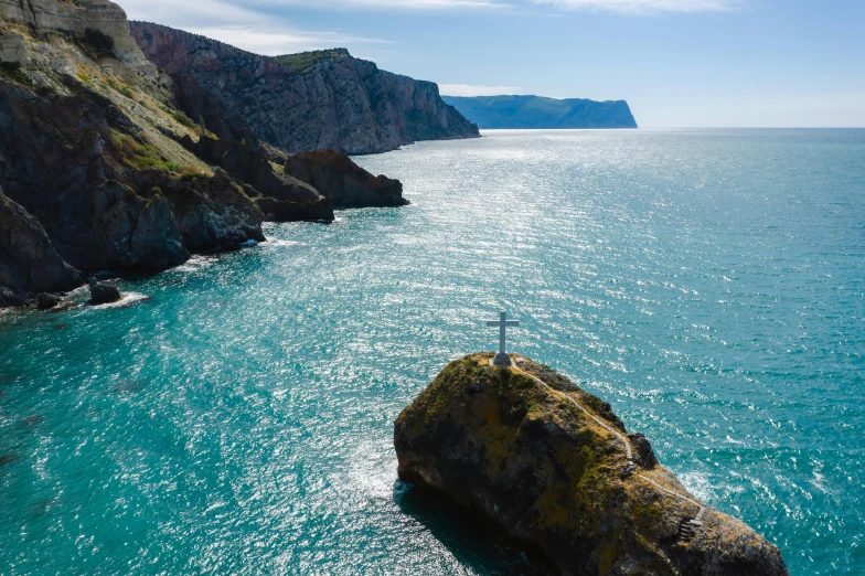 a person standing on a rock in the middle of the ocean, steep cliffs, ukraine. photography, profile image