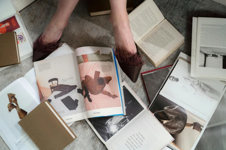 a person sitting on the floor surrounded by books, inspired by Balthus, visual art, old photobook, flatlay book collection, dezeen, feet on the ground