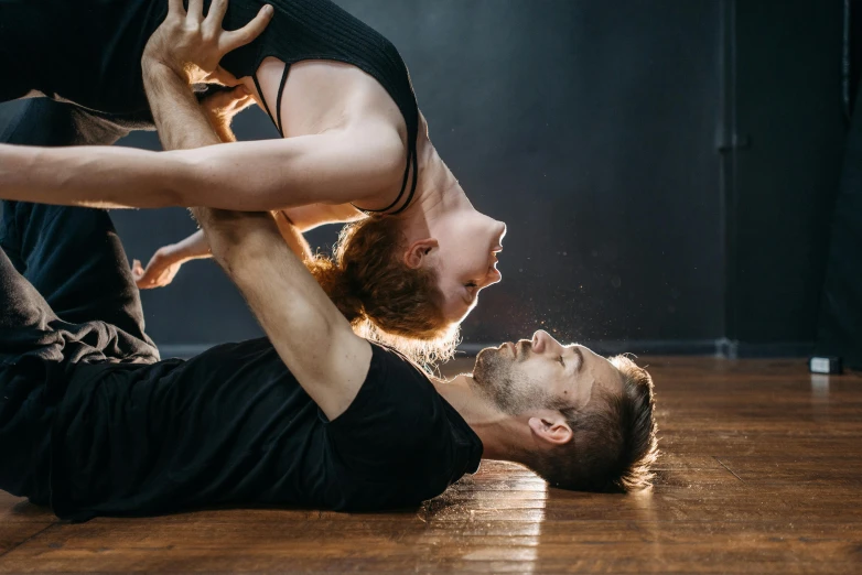 a man and a woman doing a handstand on a wooden floor, by Matija Jama, arabesque, sydney hanson, thumbnail, indoor picture, various posed