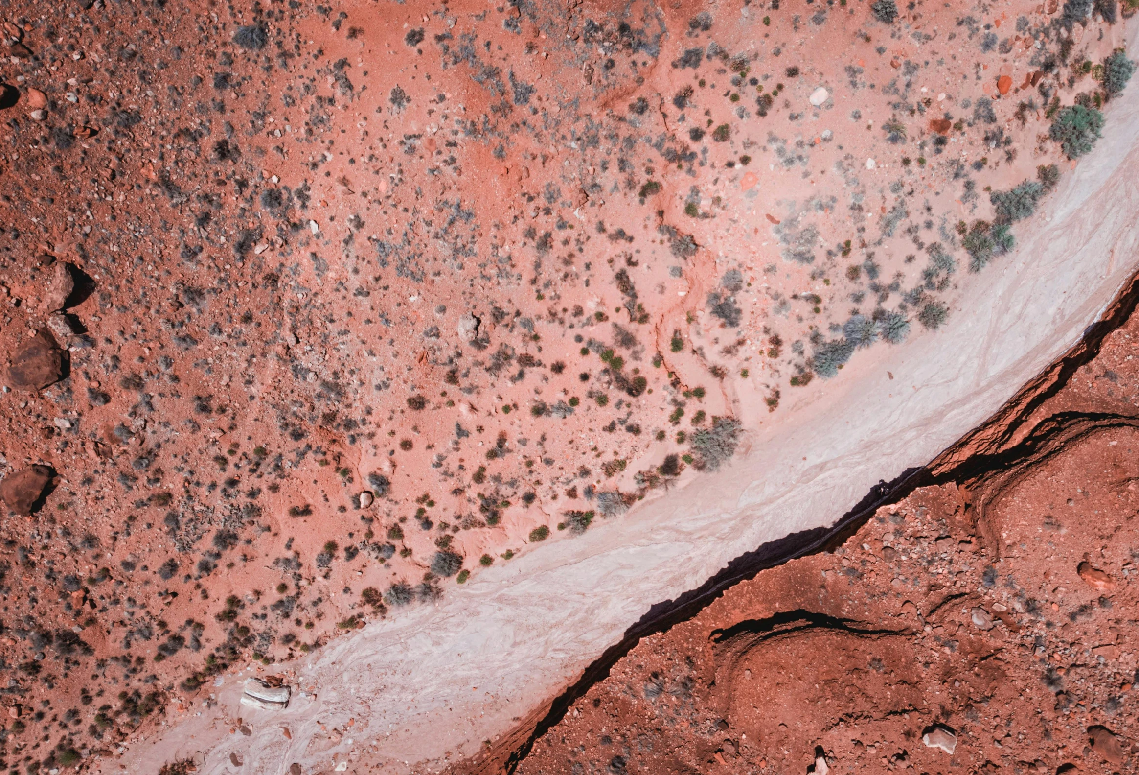 a bird's eye view of a river in the desert, by Lee Loughridge, trending on unsplash, australian tonalism, dull red flaking paint, sitting on a martian rock, partially bloody crystallized, pink white turquoise