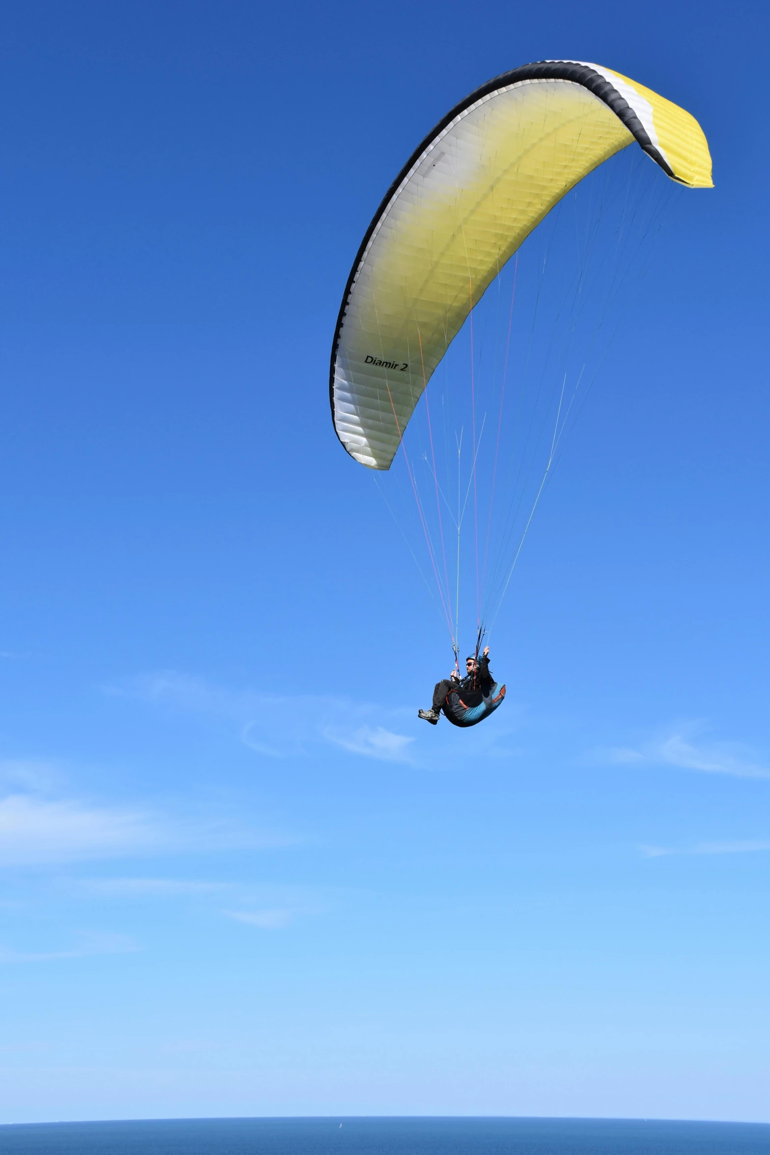 a person parasailing over the ocean on a sunny day, by David Simpson, te pae, craigville, sky!!!, touring