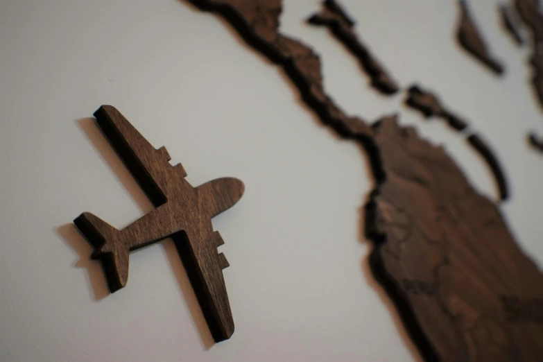 a close up of a plane on a wall, by Jaakko Mattila, pexels contest winner, conceptual art, wooden decoration, an exquisite 3 d map, detailed silhouette, flying islands