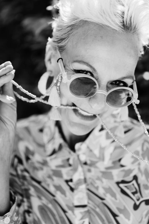 a black and white photo of a woman wearing sunglasses, a black and white photo, by Anita Malfatti, unsplash, wearing chains, beth cavener, playful smile, 4 5 yo