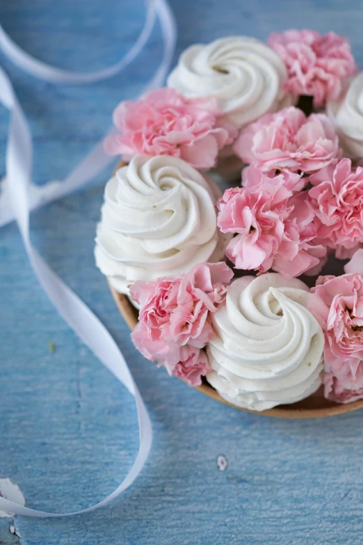 a heart shaped cupcake with white frosting and pink carnations, floating bouquets, twirls, carefully crafted, crispy