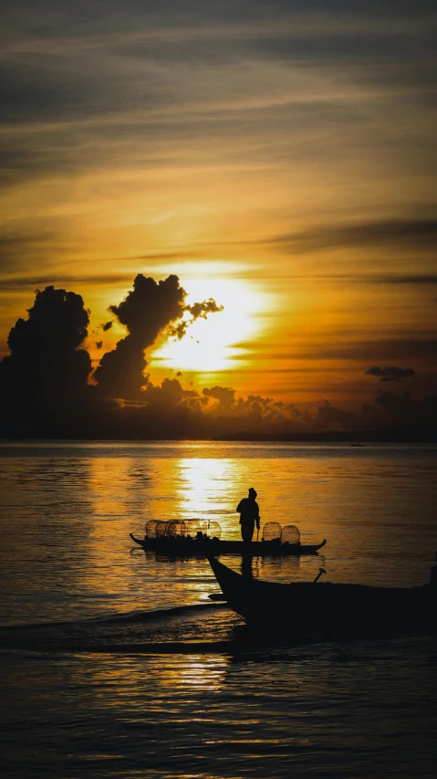 a couple of boats that are in the water, by Abidin Dino, pexels contest winner, sumatraism, silhouette of a man, ((sunset)), thumbnail, conde nast traveler photo