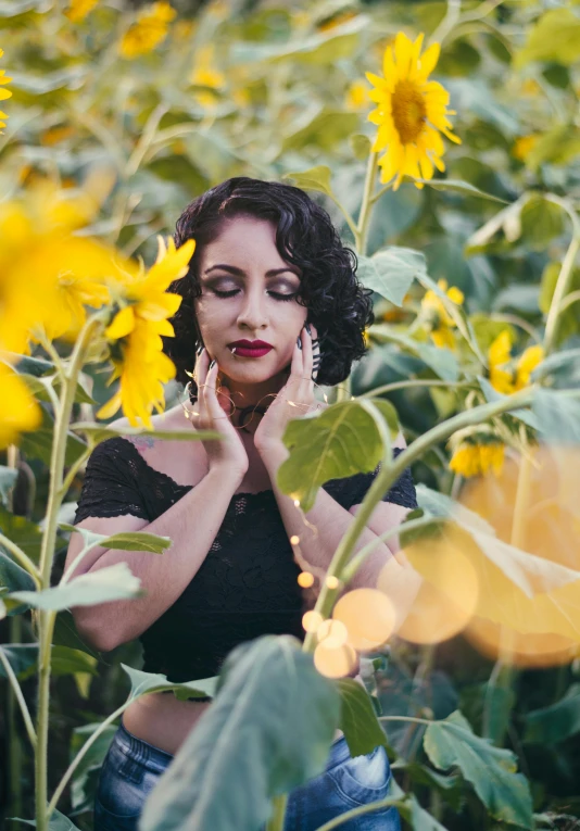 a woman standing in a field of sunflowers, inspired by Elsa Bleda, renaissance, morticia addams, square, promotional photo, lights