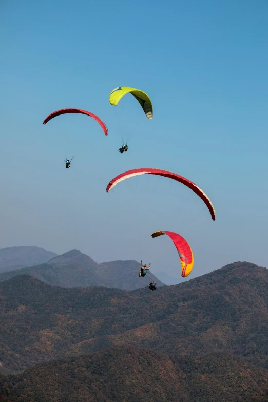 a group of people paragliding in the mountains, by Peter Churcher, india, mid morning lighting, profile image, thumbnail